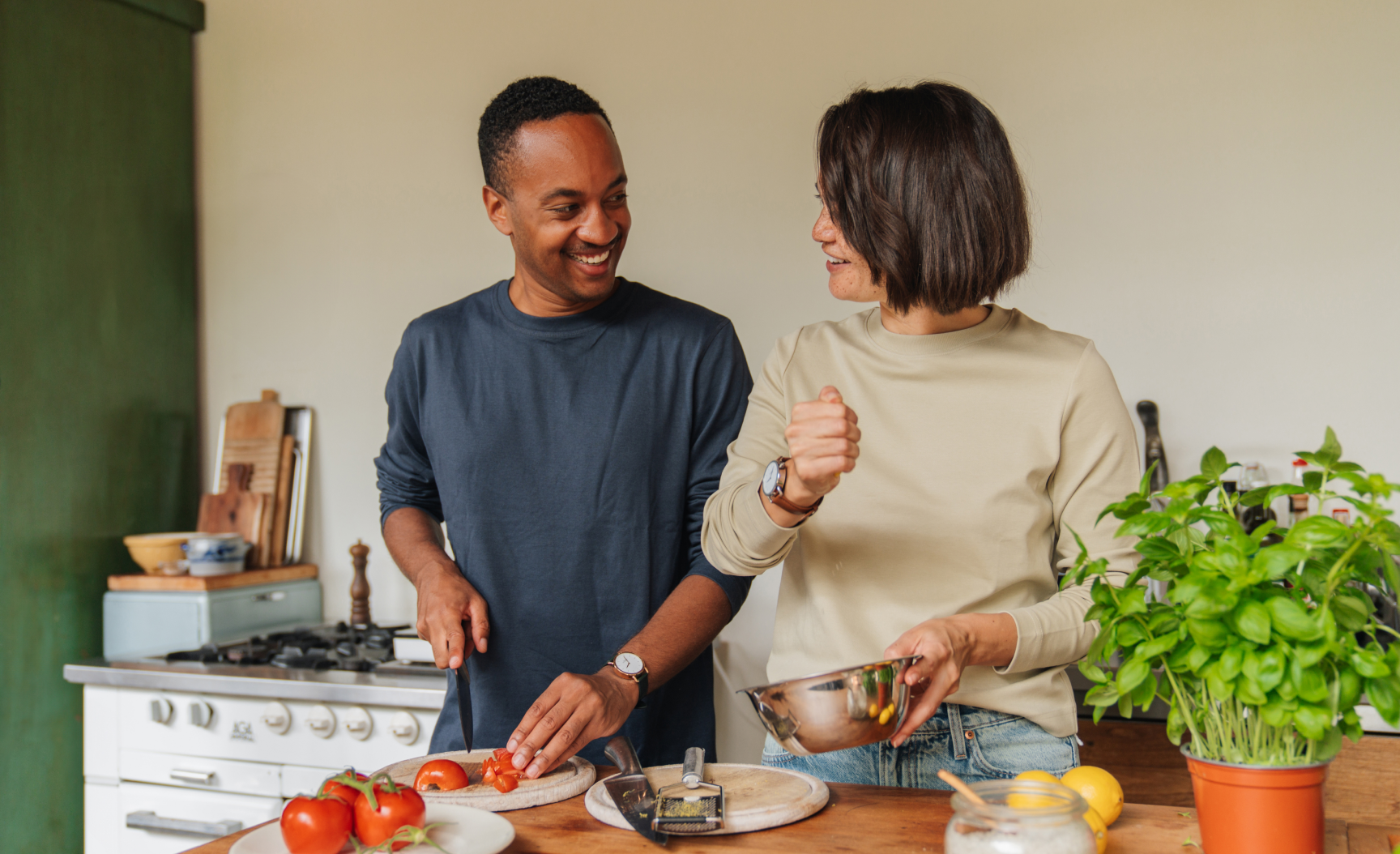 Couple laughing while cooking together 